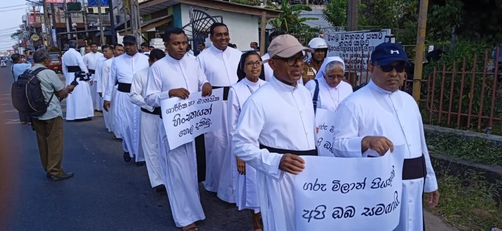 அருட்தந்தை பொலிஸாரினால் தாக்கப்பட்டமைக்கு எதிர்ப்பு – நீர்கொழும்பில் ஆர்ப்பாட்டம்